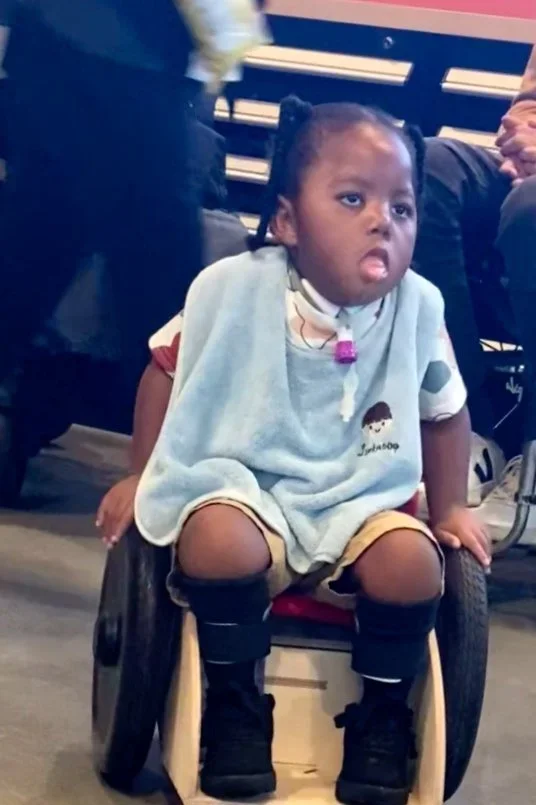 A toddler moving on his own in a mobility trainer