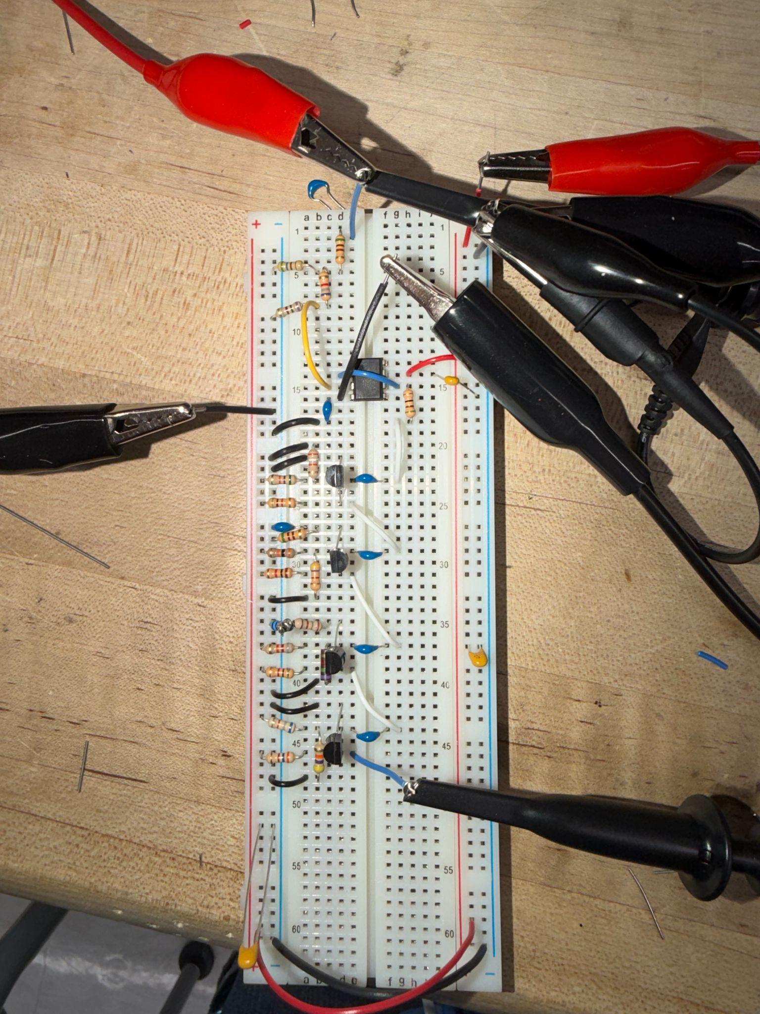 Four-stage BJT amplifier built on a breadboard with oscilloscope probes attached