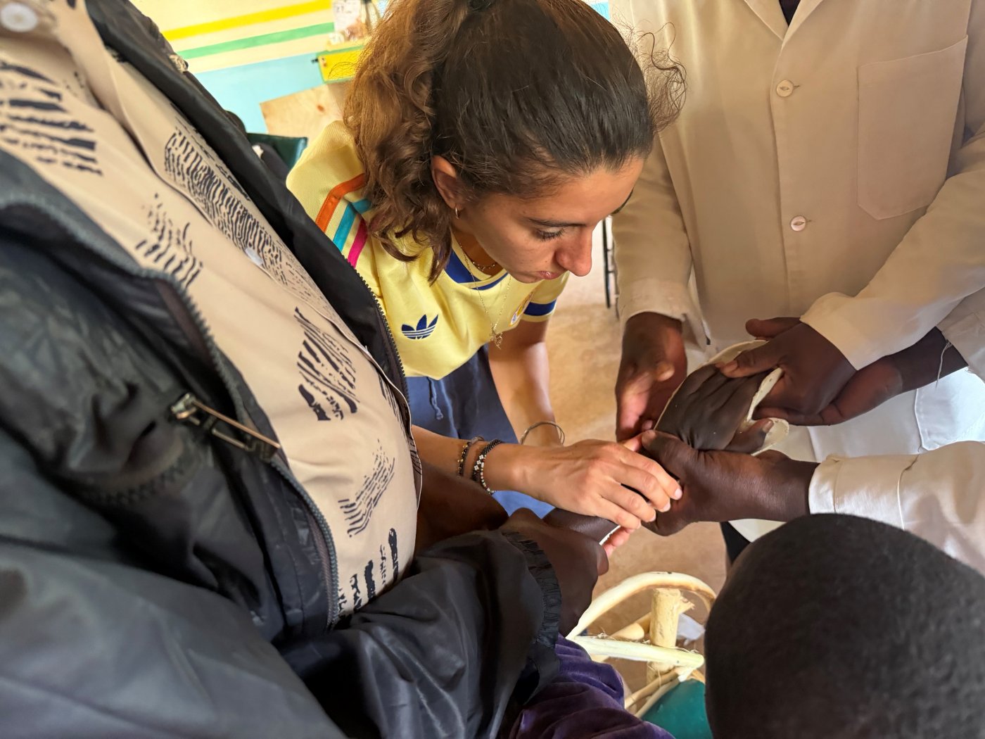 Leilani and a clinician fitting a white Orthoplast brace to a learner's hand and wrist
